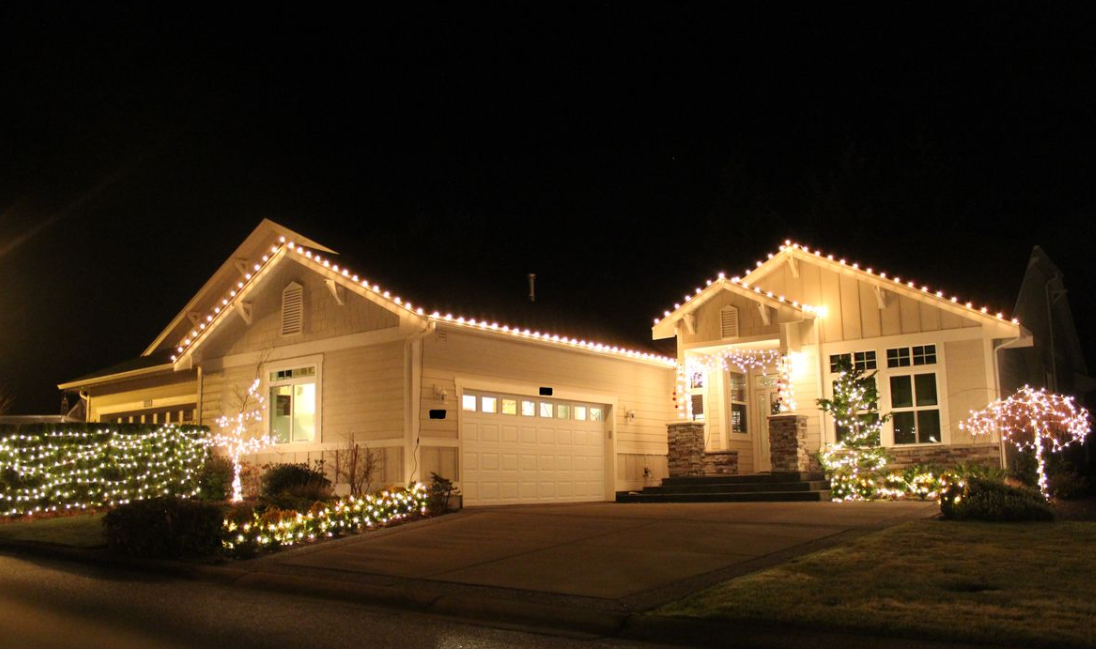 Craftsman home with warm white roofline and landscape lighting