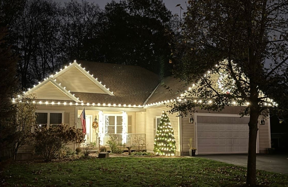 Ranch home with roofline lights and lit outdoor Christmas tree